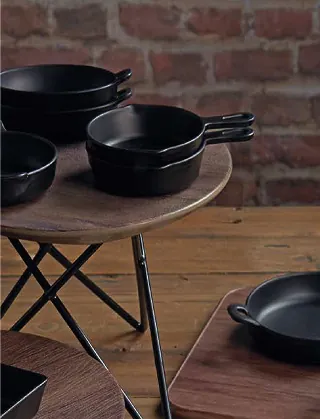 Black bowls and plates arranged on a dining table