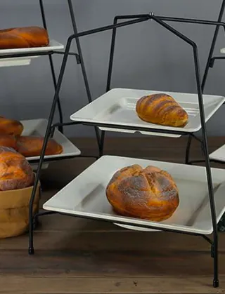 Bread displayed on black metal serving stands